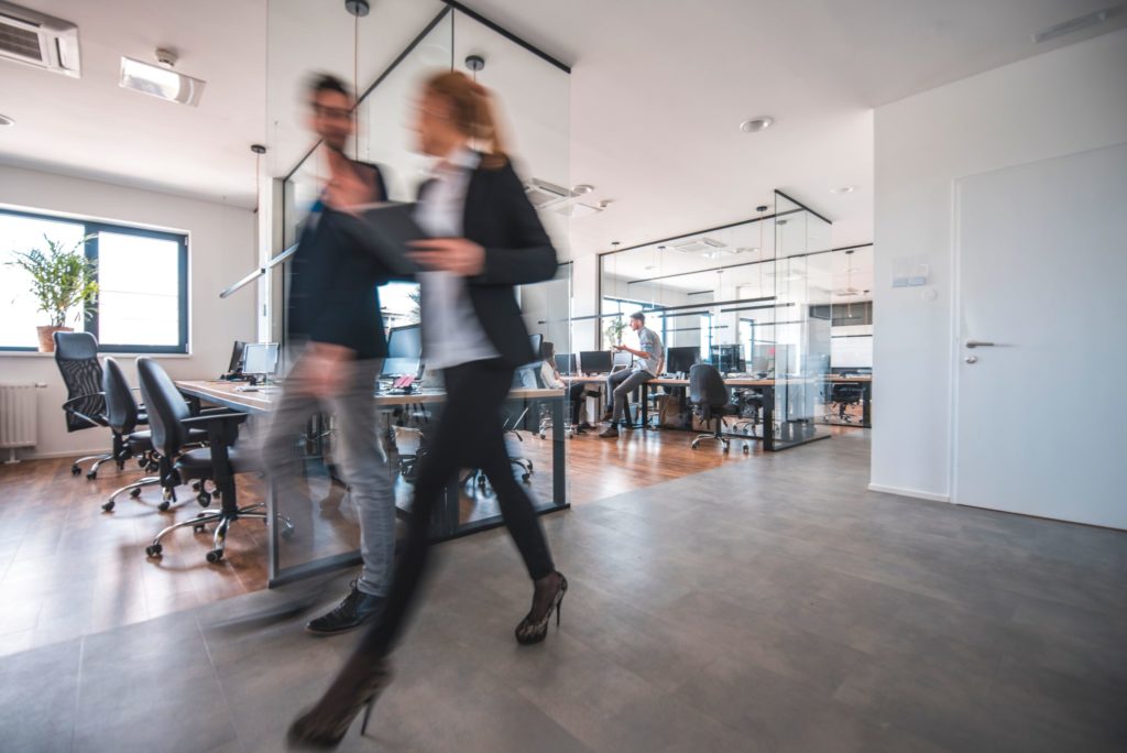 male and female walking through an office talking